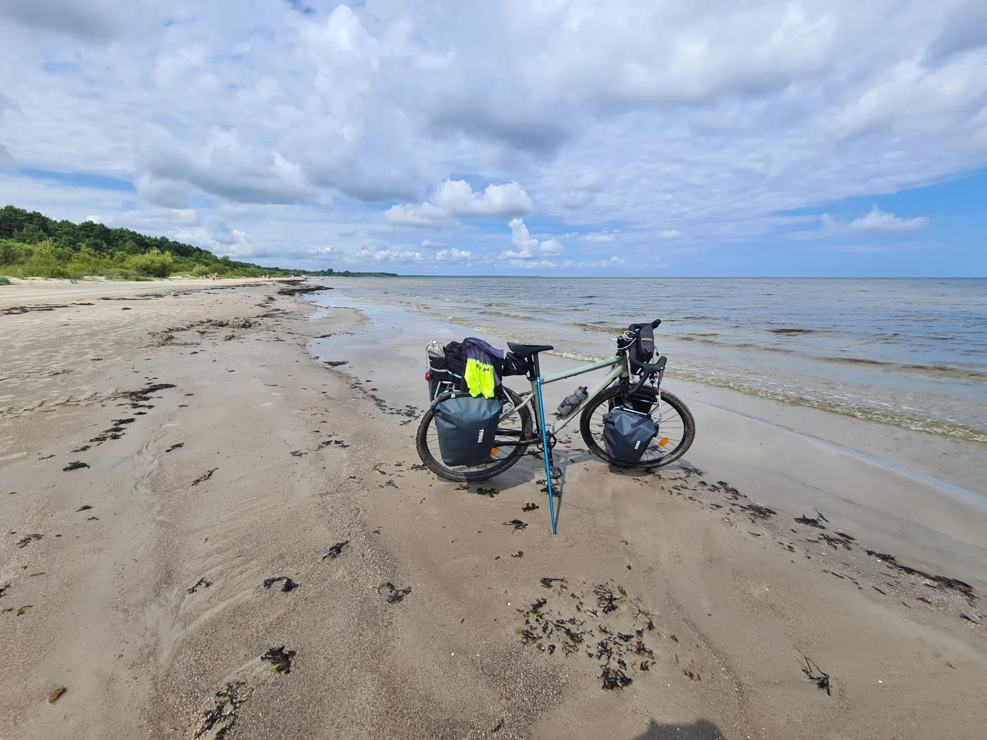 A loaded touring bike propped on an empty beach